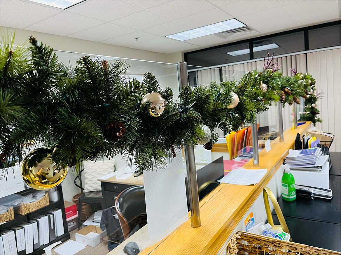 A row of vases filled with christmas decorations in an office.