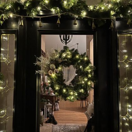 A christmas wreath is hanging on the door of a house.
