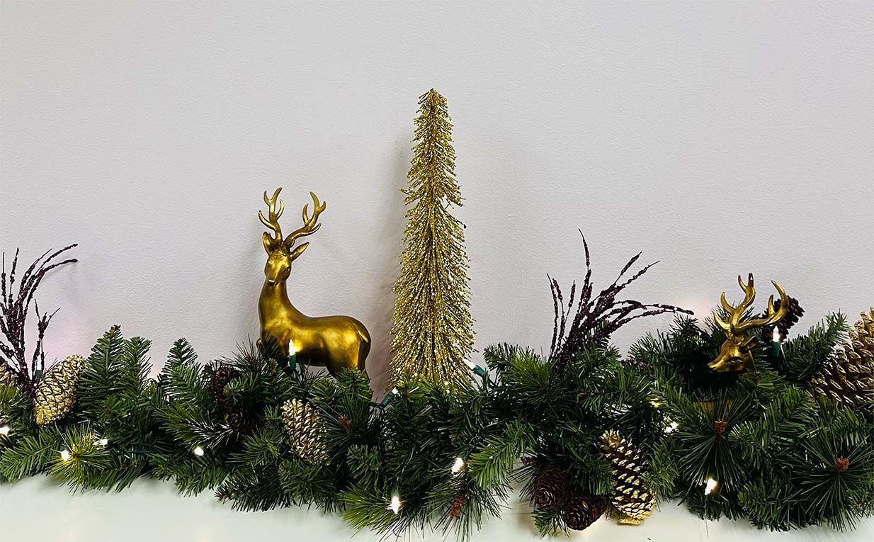 A christmas garland with a gold deer and trees