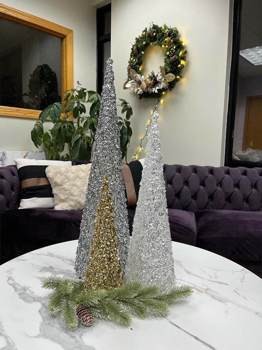 Three christmas trees are sitting on a table in a living room.