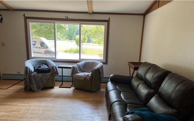 A living room with a couch and two chairs