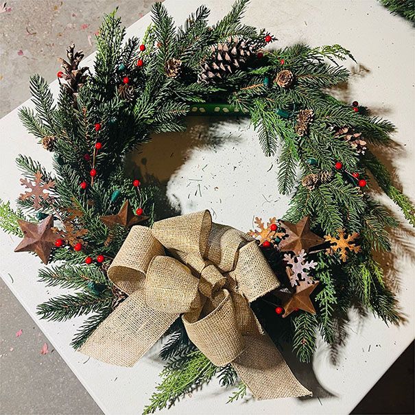 A christmas wreath with a bow is sitting on a table.
