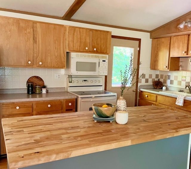 A kitchen with wooden cabinets and a wooden counter top