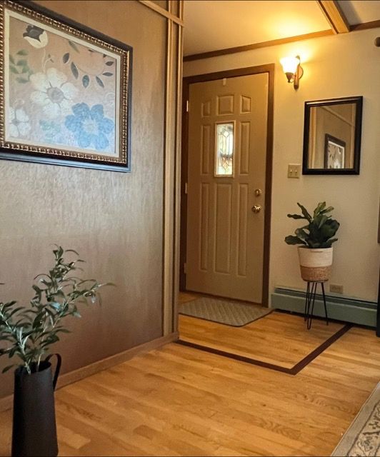 A picture of flowers hangs above a door in a hallway