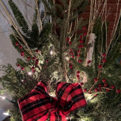 A christmas tree with a red and black plaid bow