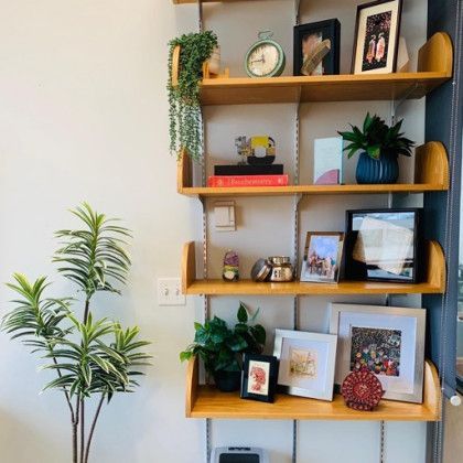 A wooden shelf with pictures and a clock on it