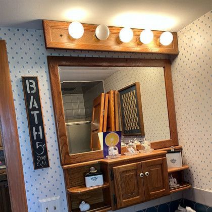A bathroom with a large mirror and a sign that says bath
