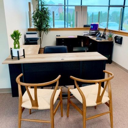 Two chairs are sitting in front of a desk in an office.
