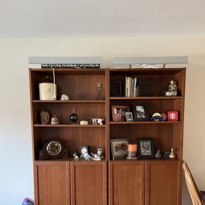 A living room with wooden shelves and a clock on top