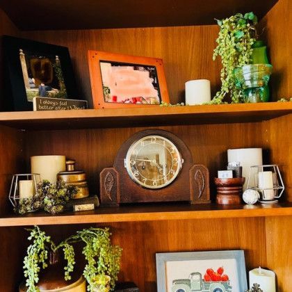 A wooden shelf with a clock on top of it