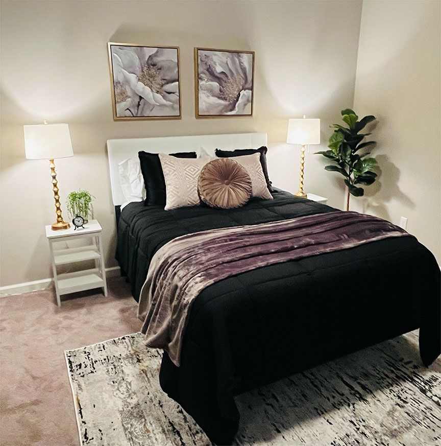 A bedroom with a bed and two pictures on the wall