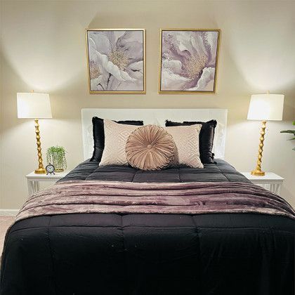 There are two paintings on the wall above the bed.