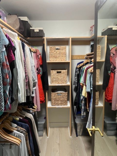 A walk in closet filled with clothes and baskets