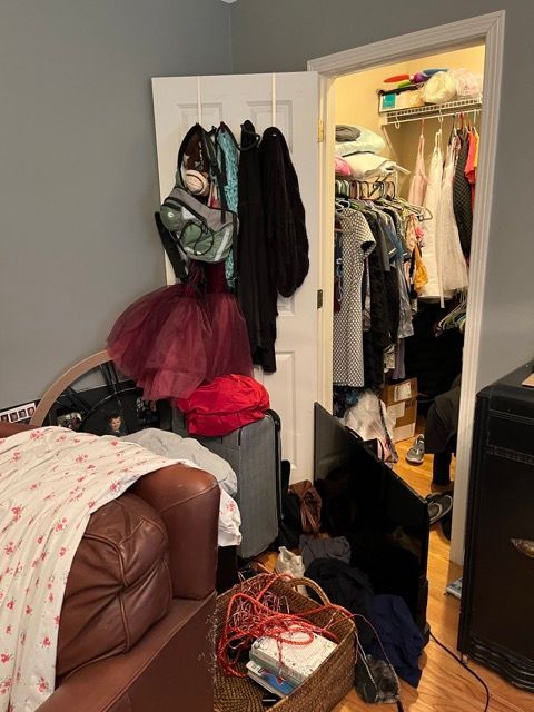 A messy room with a closet and a couch