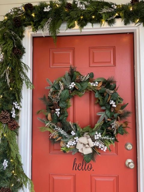 A red door with a christmas wreath on it.