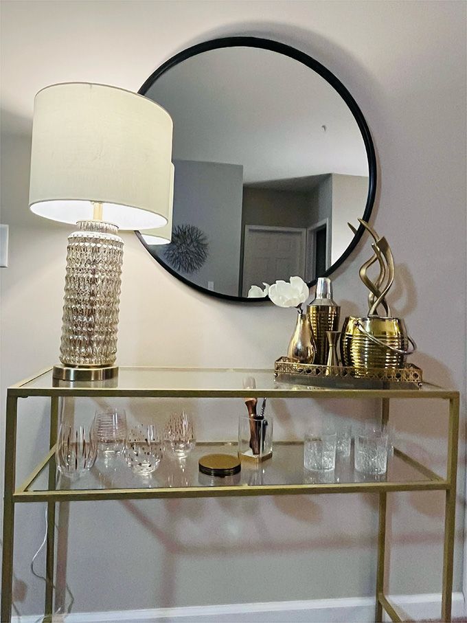 A table with a lamp and a mirror on it