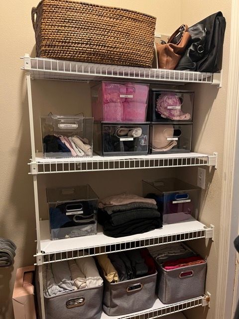 A closet filled with lots of clothes and baskets.