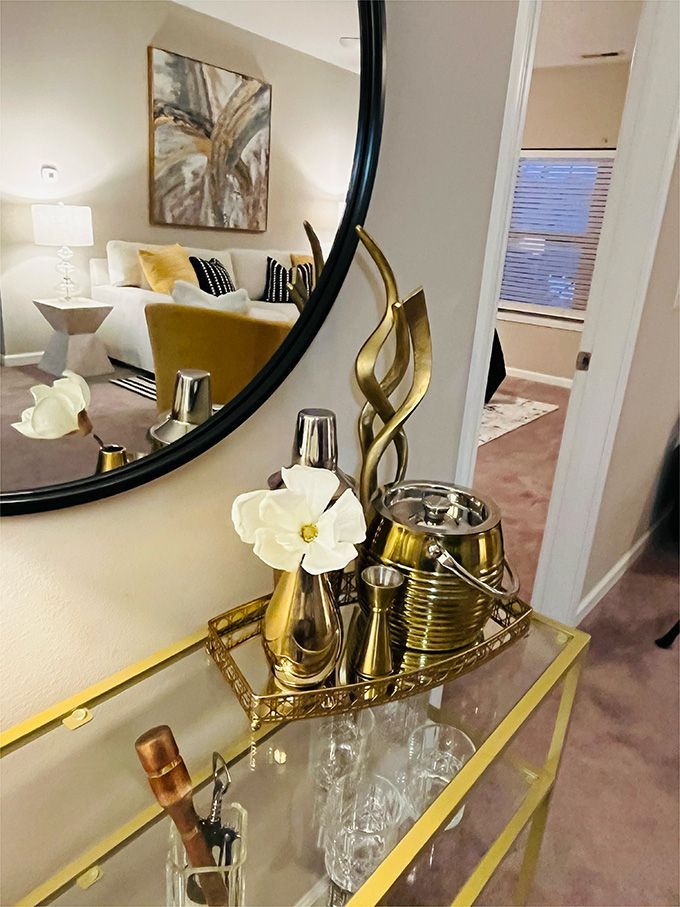 A table with a bottle of champagne and glasses on it in front of a mirror.