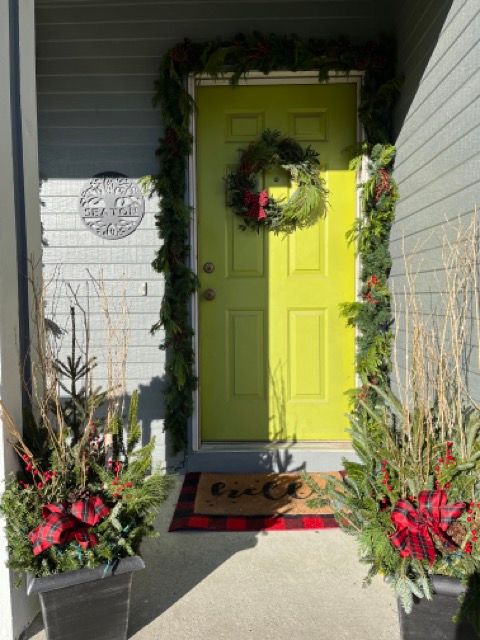 A yellow door with a christmas wreath on it