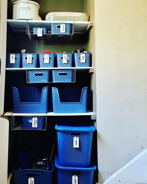 A closet filled with blue bins and shelves