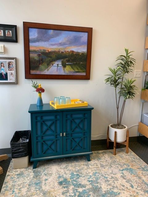 A blue cabinet with a picture on the wall above it