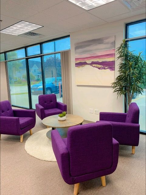 A living room with purple chairs and a coffee table