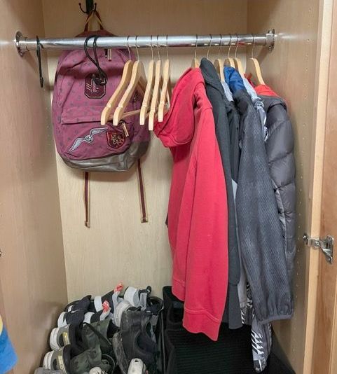 A closet filled with clothes and a backpack