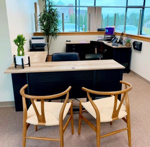 Two chairs sit in front of a desk in an office