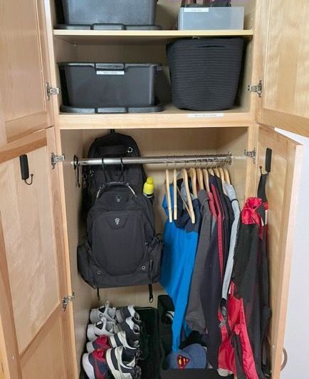 A closet filled with clothes shoes and a backpack