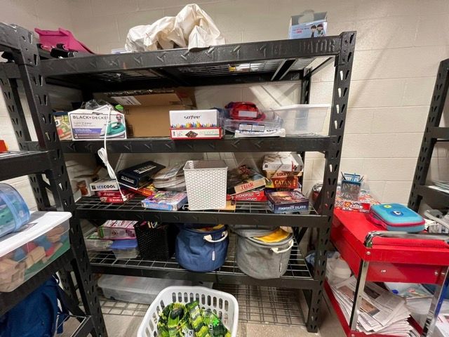 A room filled with shelves and a basket of toys.