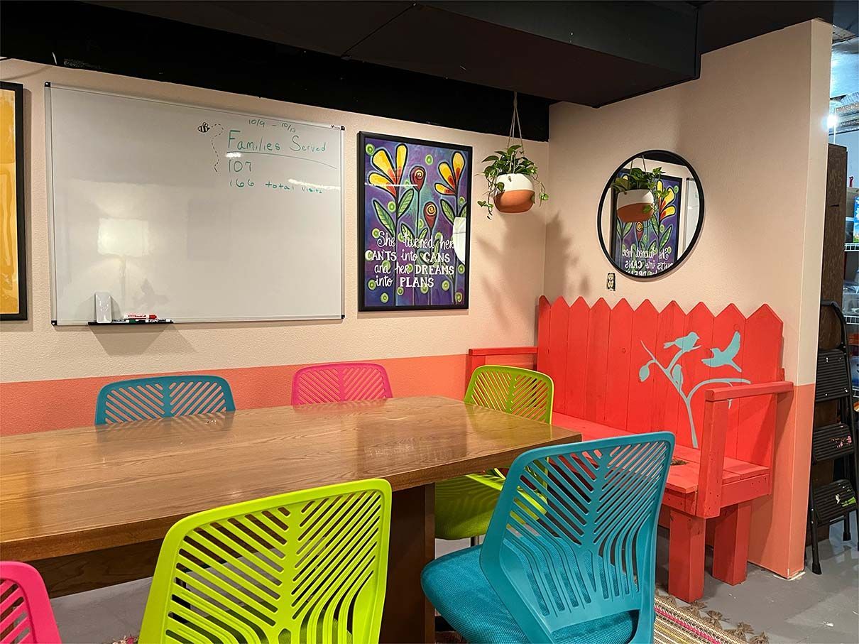 A room with a table and chairs and a whiteboard.