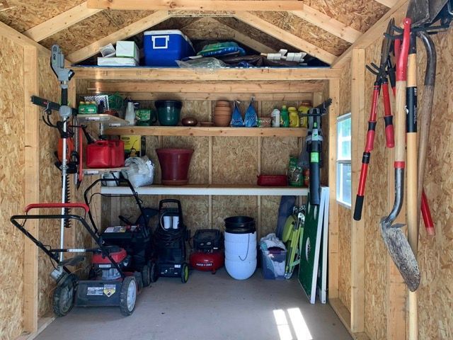 A shed filled with tools and a lawn mower
