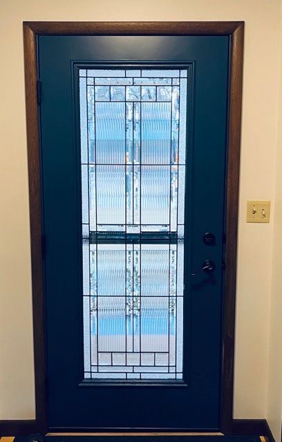 A blue door with a stained glass window in a room.