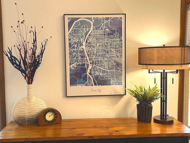 A map of a city is hanging on a wall above a wooden table.
