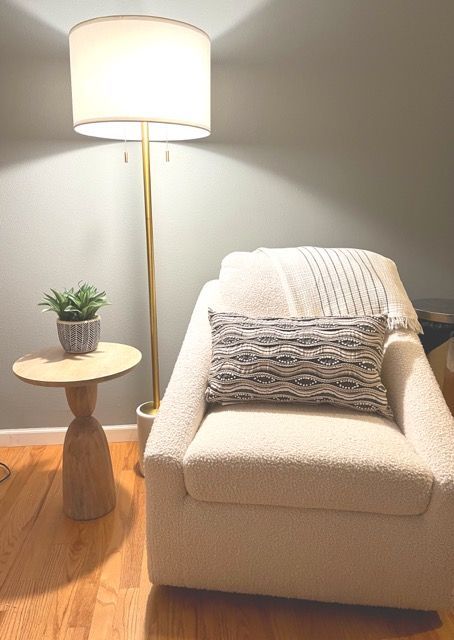 There is a chair and a lamp in the room.