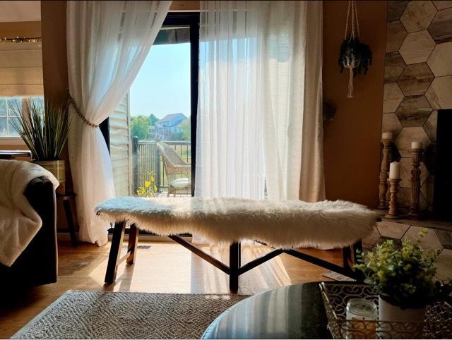 A living room with a bench and a sliding glass door