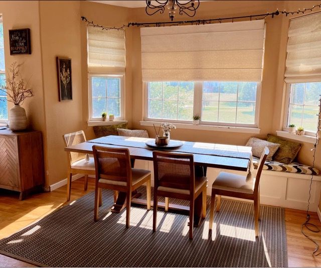 A dining room with a table and chairs and a window seat
