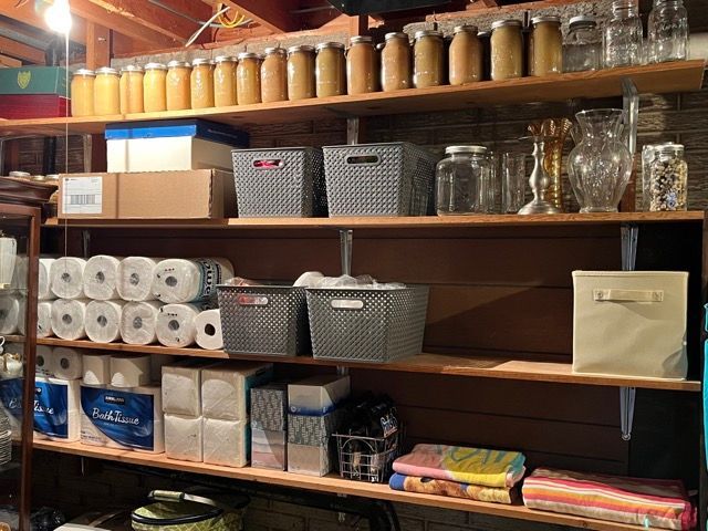 A shelf filled with lots of items including toilet paper