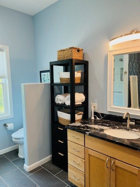 A bathroom with a sink a toilet and a mirror