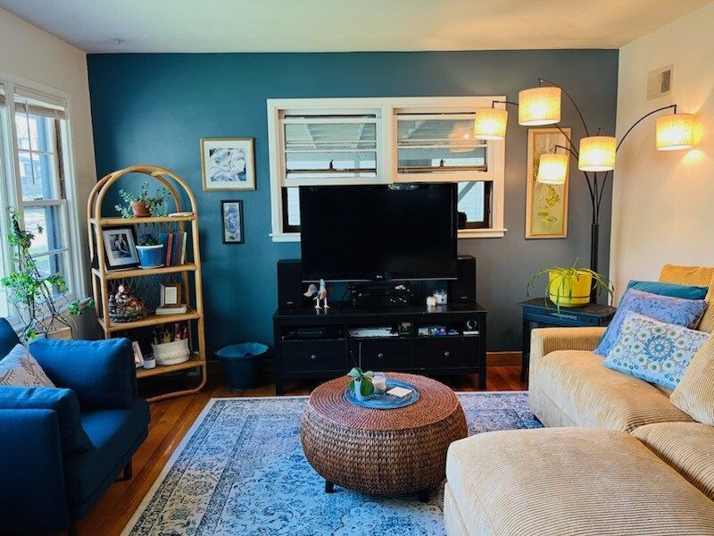 A living room with a couch , chairs , and a television.