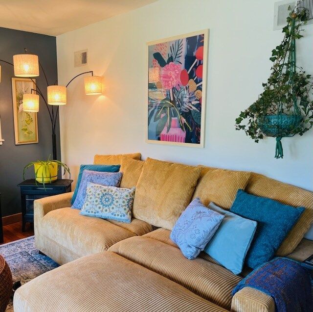 A living room with a couch and a picture on the wall