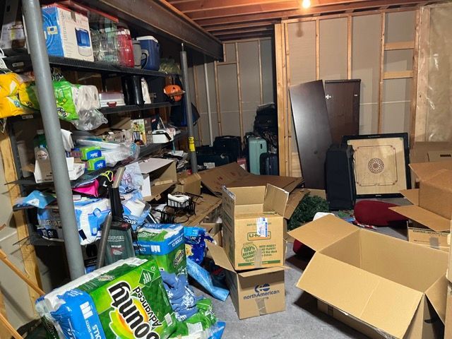 A messy basement filled with boxes and toilet paper