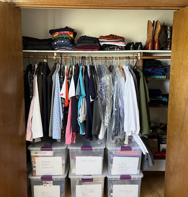 A closet filled with lots of clothes and purple bins