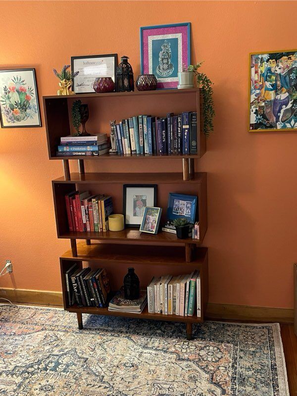A bookshelf filled with books and pictures in a living room.