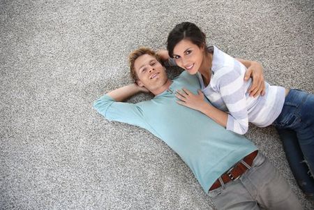 Young couple laying on their new carpet