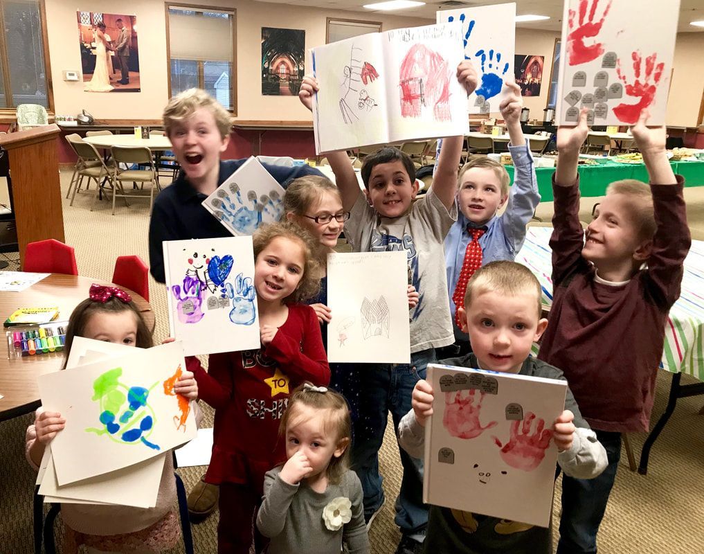 A group of children are holding up their hand prints.