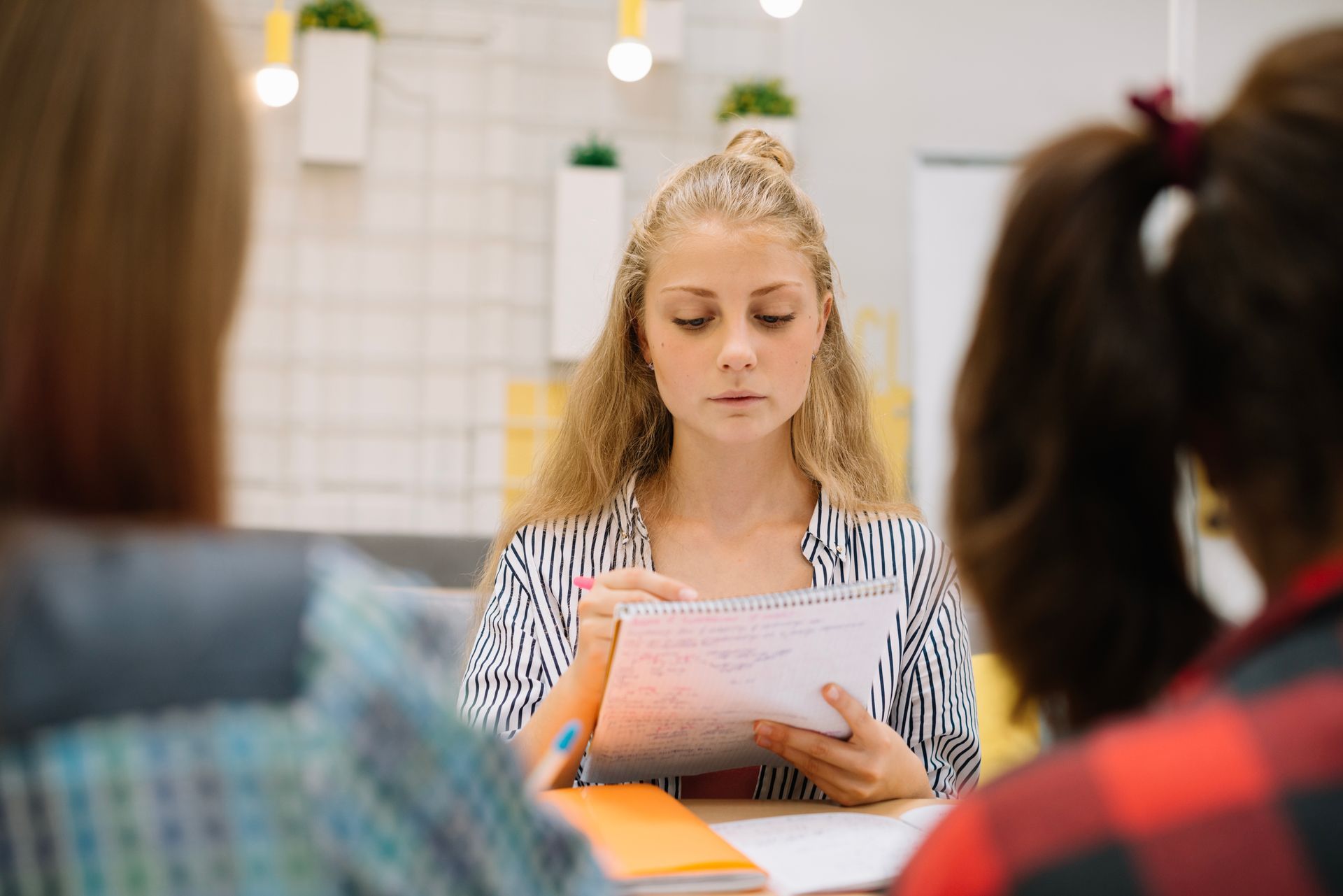 A woman is sitting at a table holding a piece of paper.