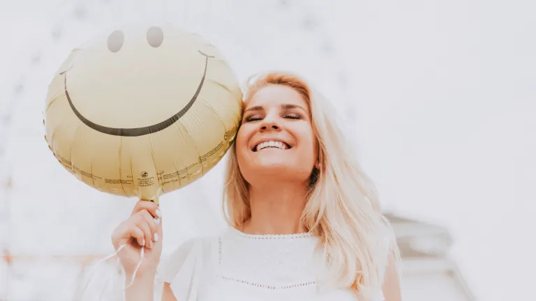 Happy Woman Holding Smiley Balloon — Supplements & Organic Produce in Mid North Coast, NSW