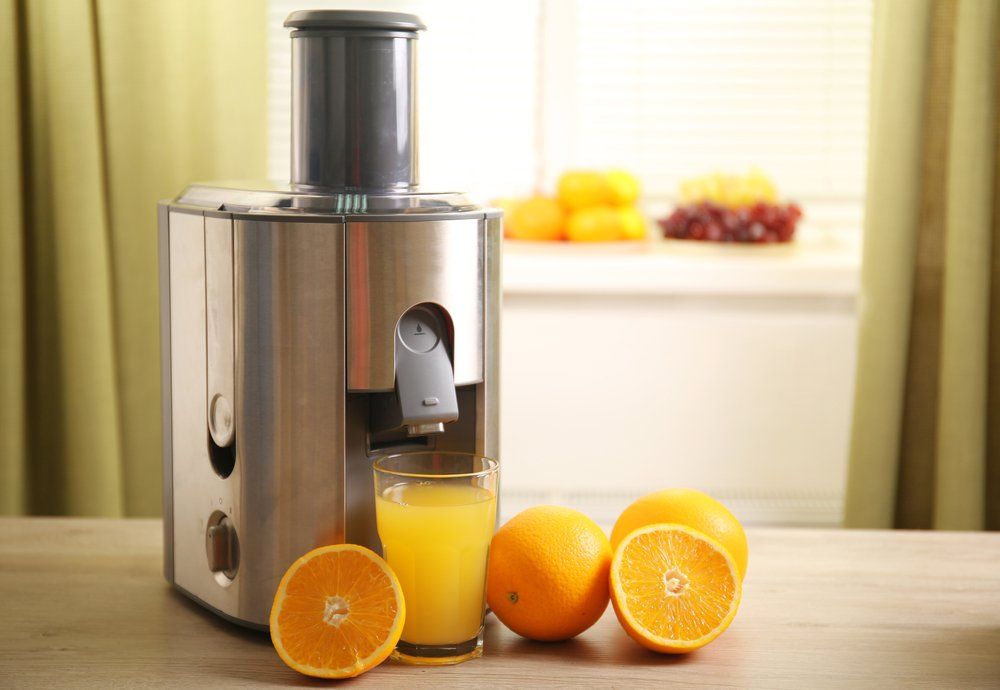 Juicer and Orange Juice on Kitchen Table — Appliances Store in Mid North Coast, NSW