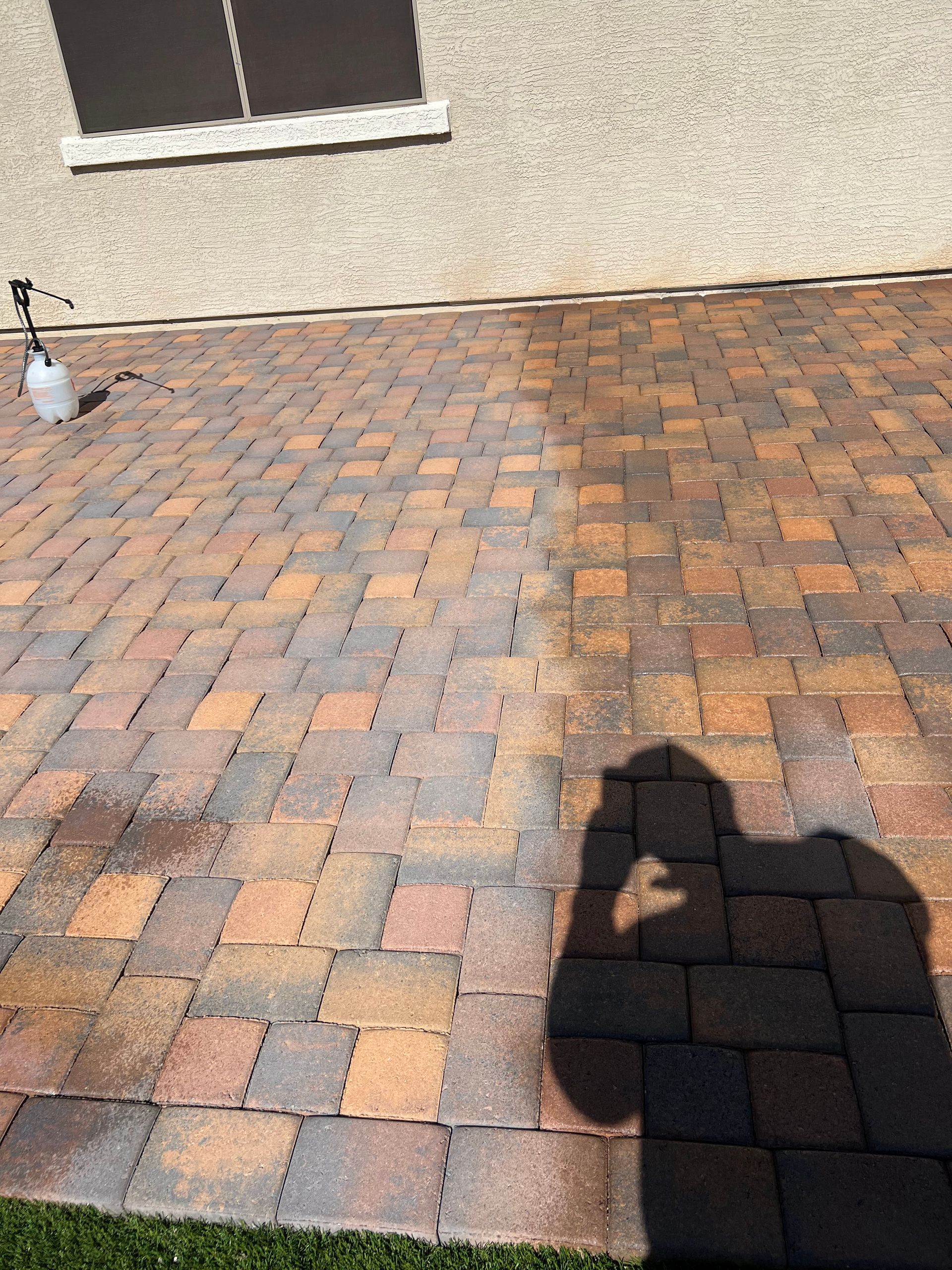 Brick patio partially cleaned, showing stark contrast between dirty and cleaned sections.